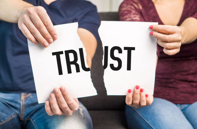 the break of the word trust on a piece of paper between two people