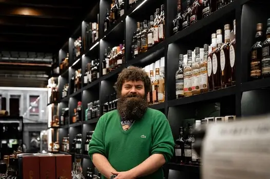 liquor store manager smiling behind the cash register