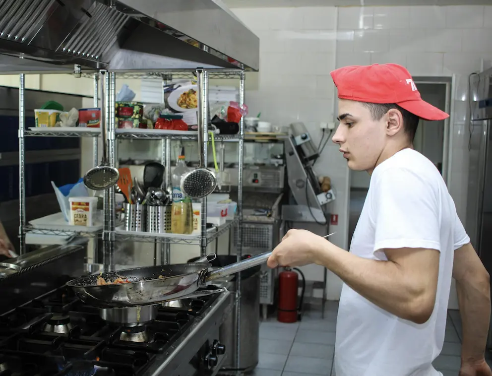 line cook making food at a restaurant in the kitchen